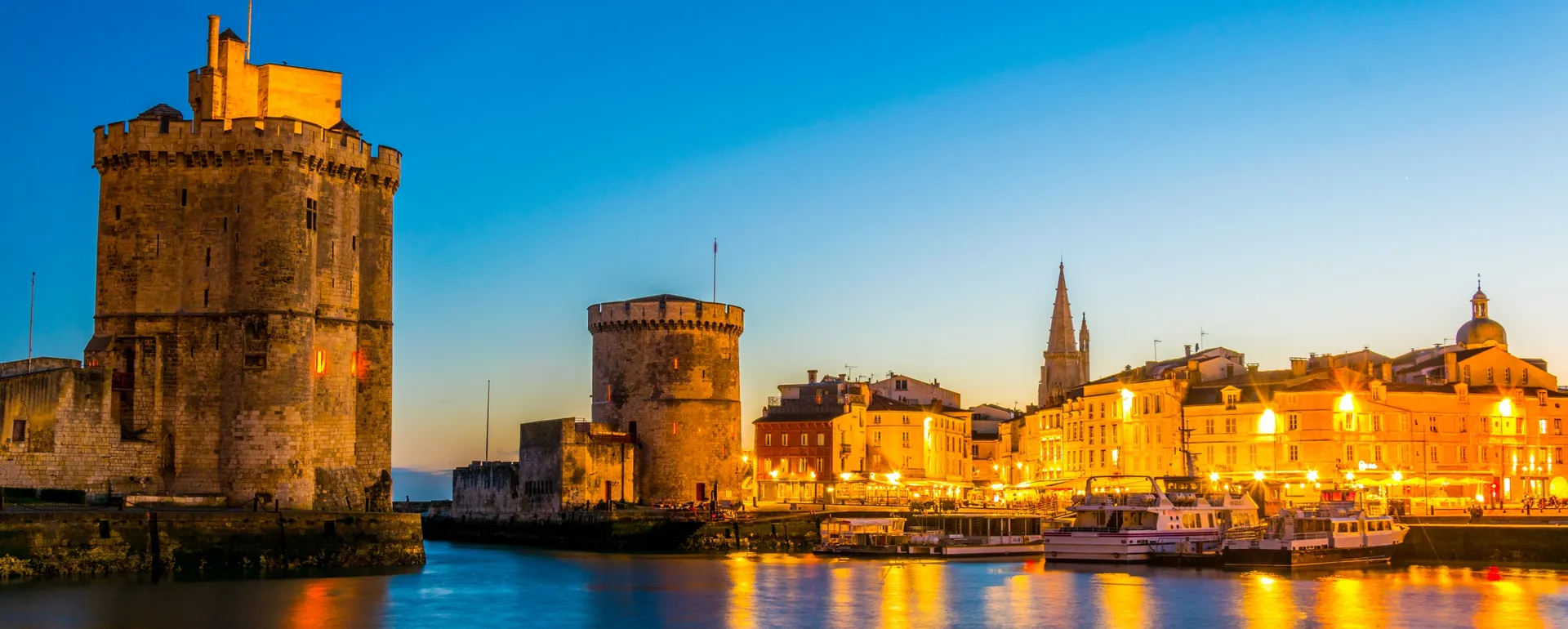 Vivre à La Rochelle : le Vieux-Port au coucher du soleil, avec la tour Saint-Nicolas et la tour de la Chaîne