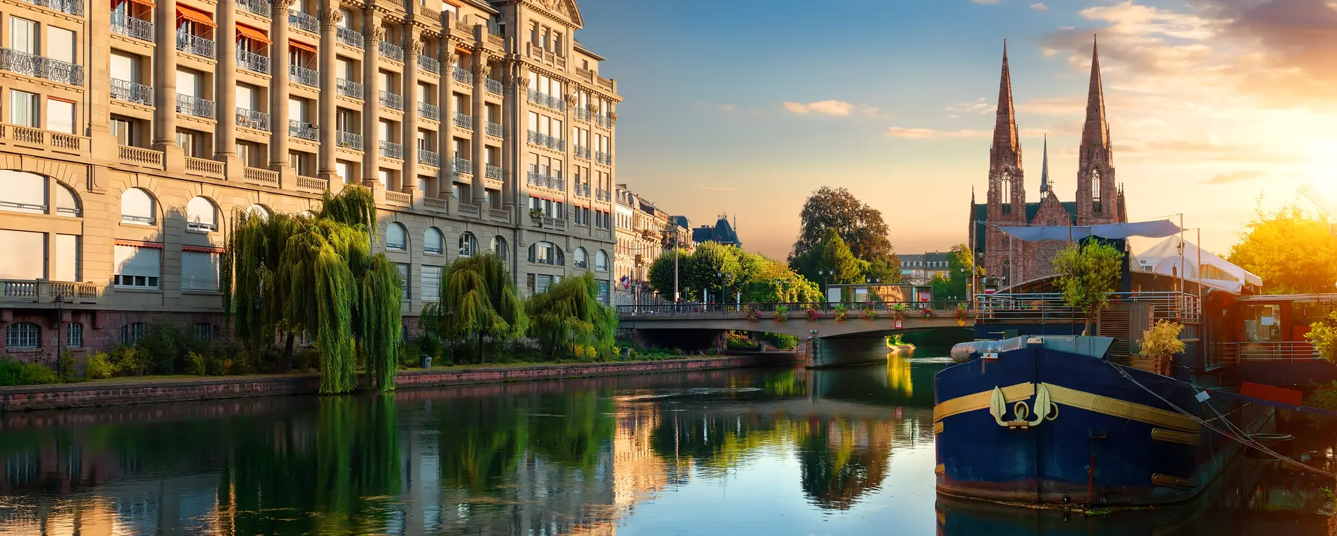 Vivre à Strasbourg — les quais de l'Ill au lever du jour, avec l'église Saint-Paul