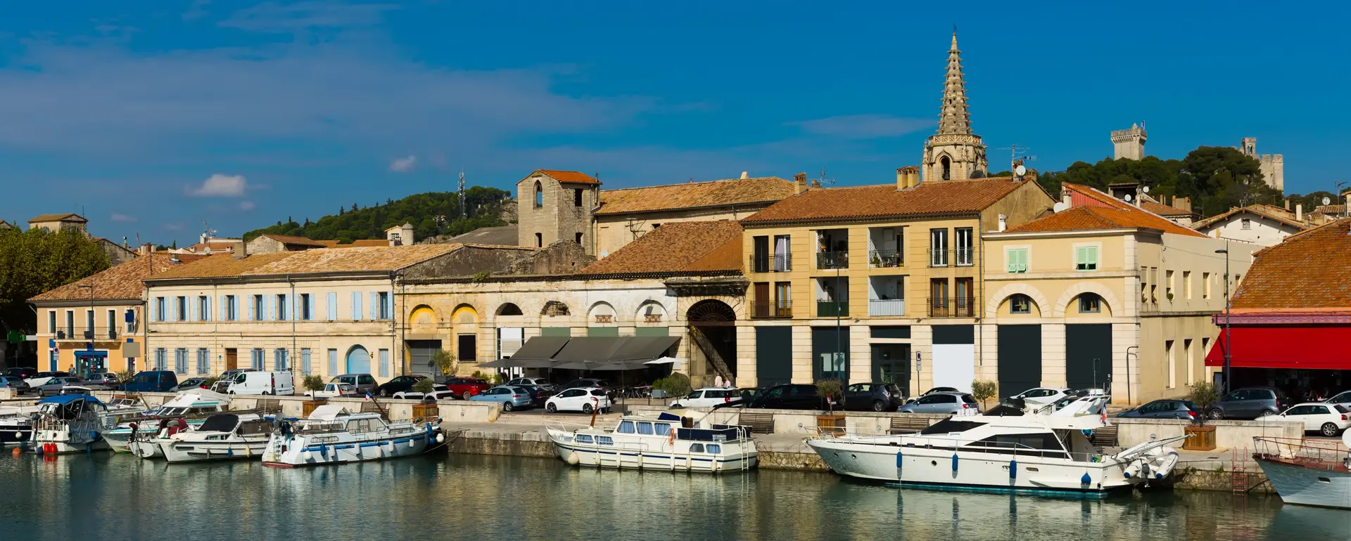 Vivre à Beaucaire — port de plaisance sur le canal du Rhône à Sète, flèche de l'église Saint-Paul et tours du château