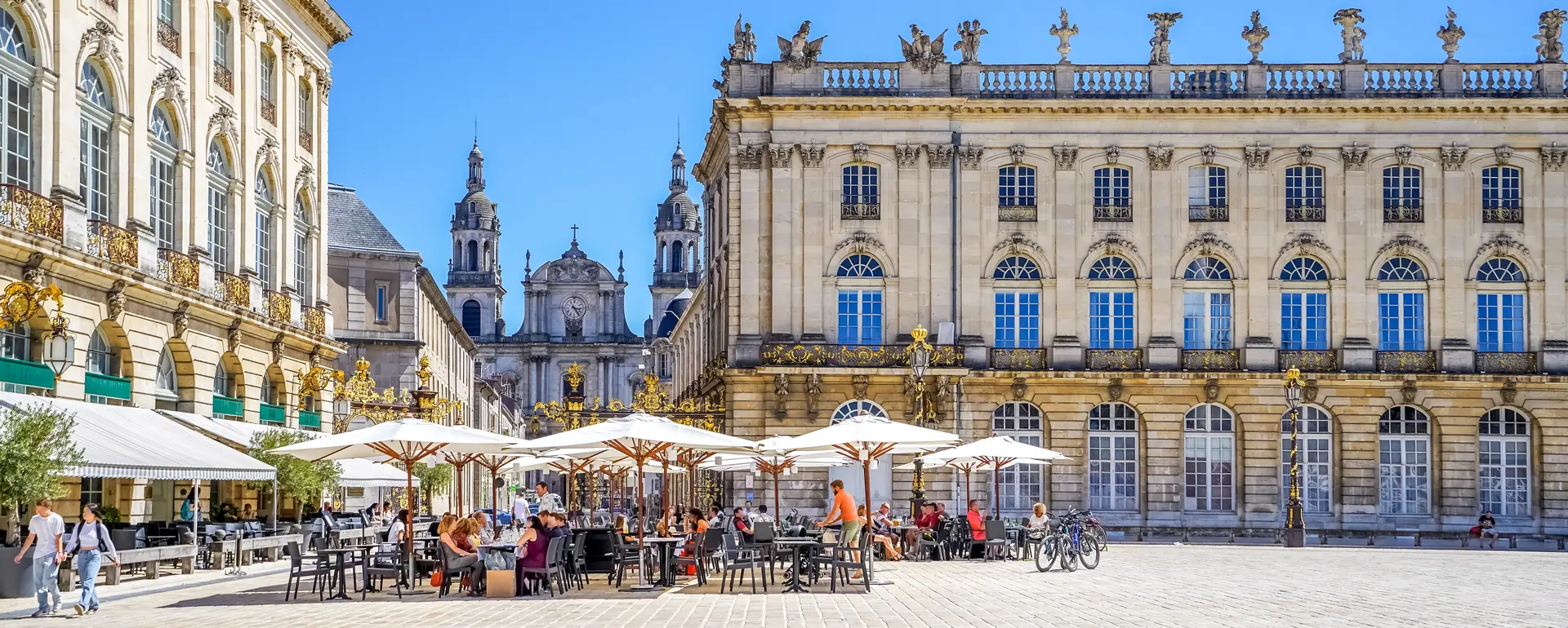 Vivre à Nancy — terrasses de la place Stanislas devant le Grand Hôtel de la Reine, avec la cathédrale au fond